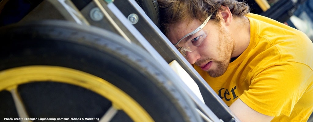 Team member Will Horner adjusts steering alignment on a mule chassis used to test many of Novum's mechanical components.